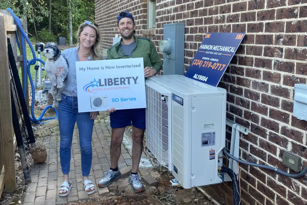 Heat Pump Installation Costs - Happy customer standing next to Harmon Mechanical rep. Both are standing on the side yard next to a newly installed heat pump.