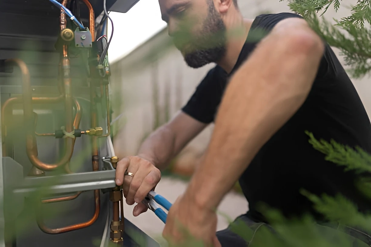 Man performing maintenance on an HVAC unit