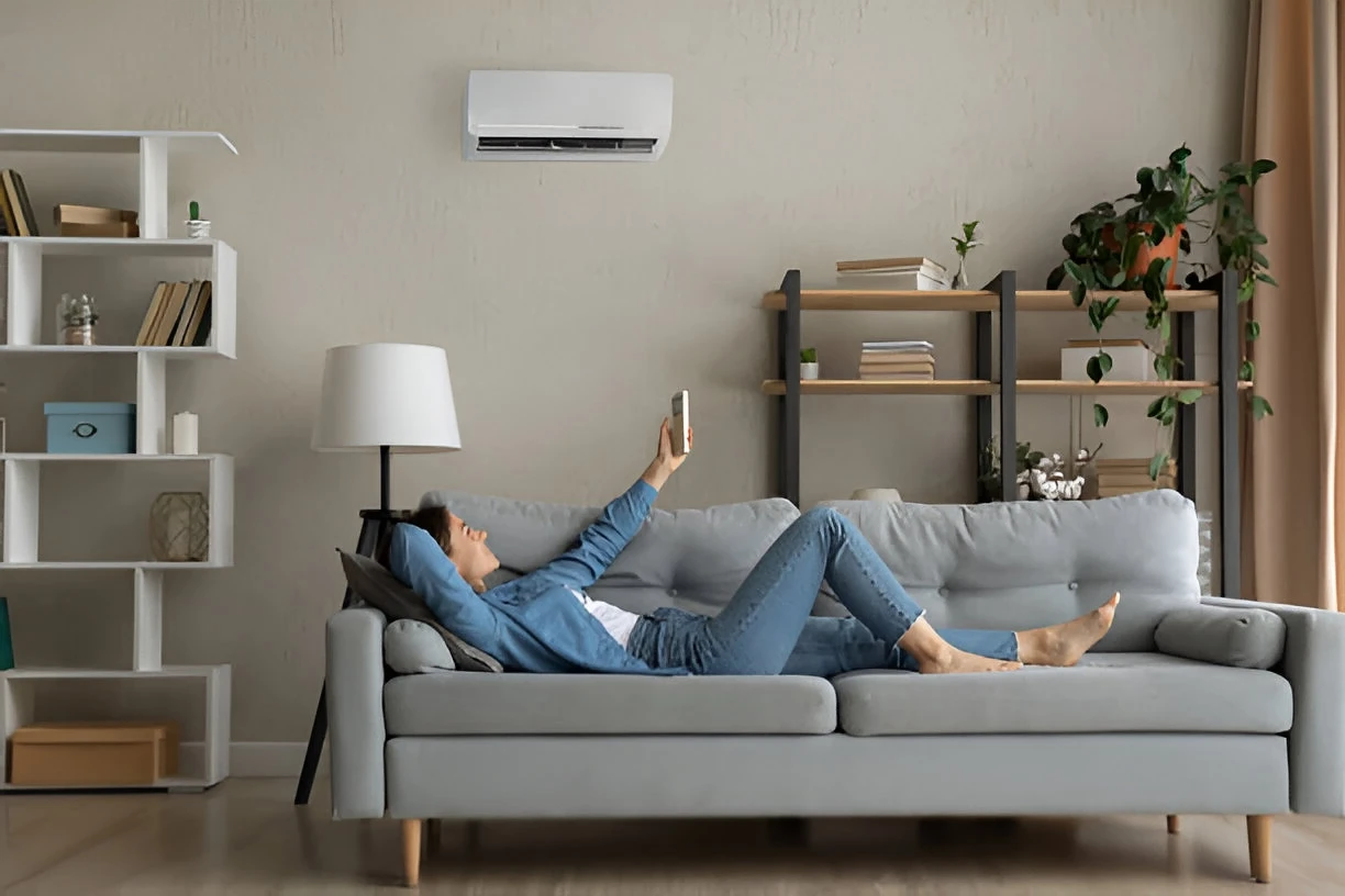 Woman controlling a mini split unit with a remote control