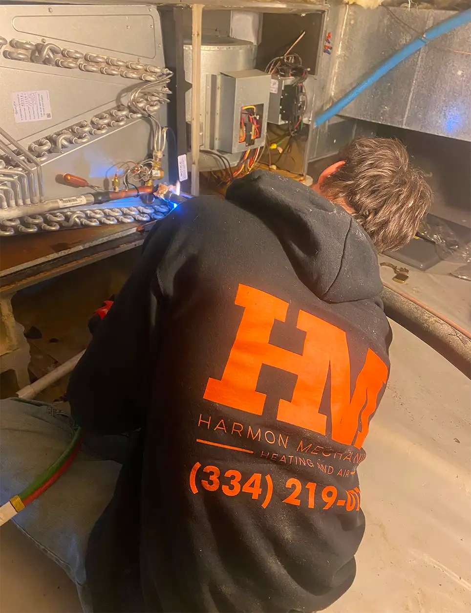 Harmon Mechanical team member working on an HVAC unit