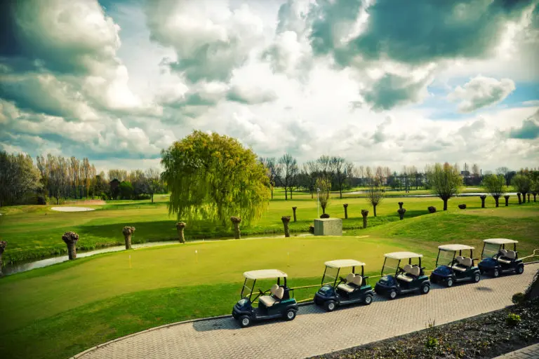 Golf carts lined up on a country club fairway and green, illustrating financial services for