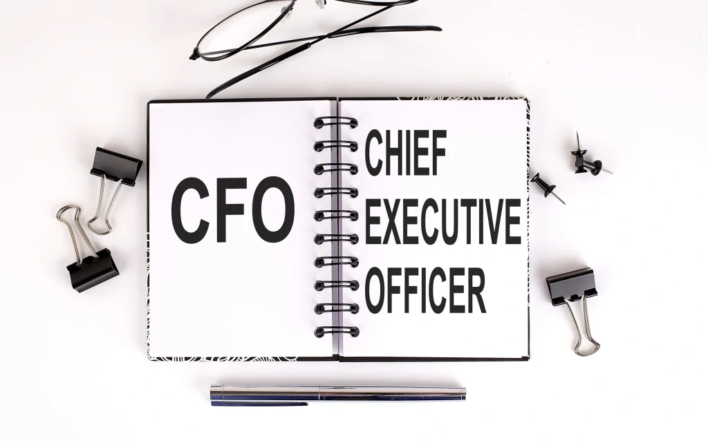 Open notebook with "Chief Financial Officer" text and office supplies, illustrating fractional CFO services.