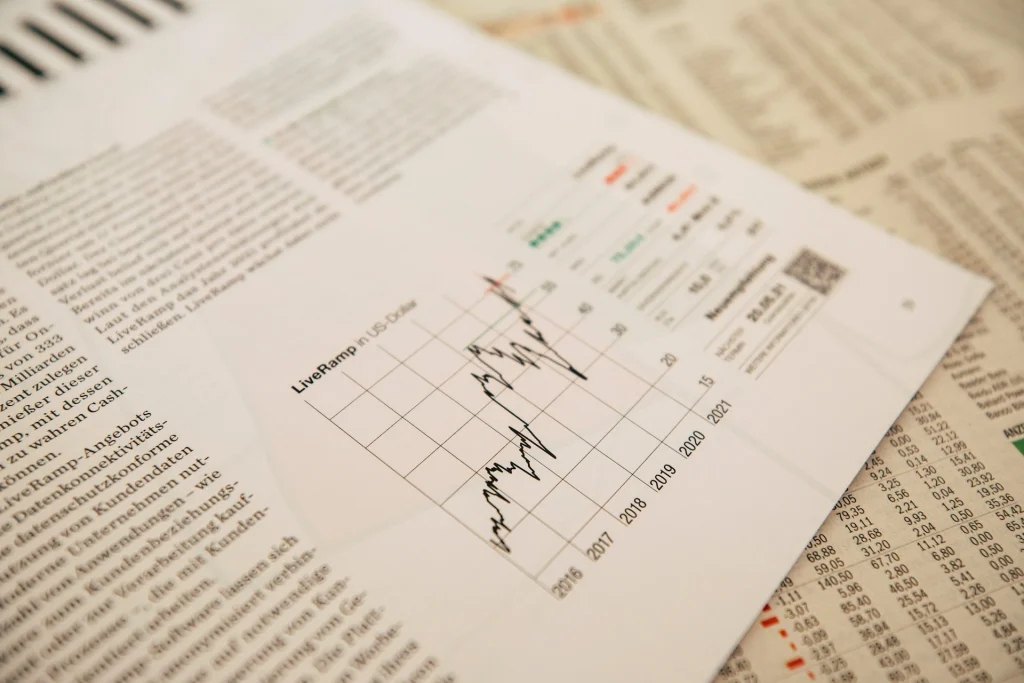 LiveRamp stock price chart from 2016 to 2021 printed on a financial report over newspaper pages.