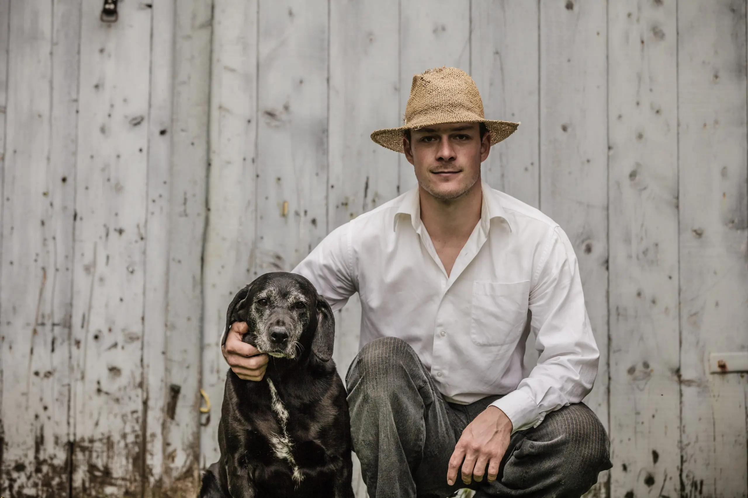 Image of a man wearing a cowboy hat beside a dog