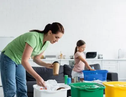 Mother and daughter sorting plastic and paper during spring cleaning
