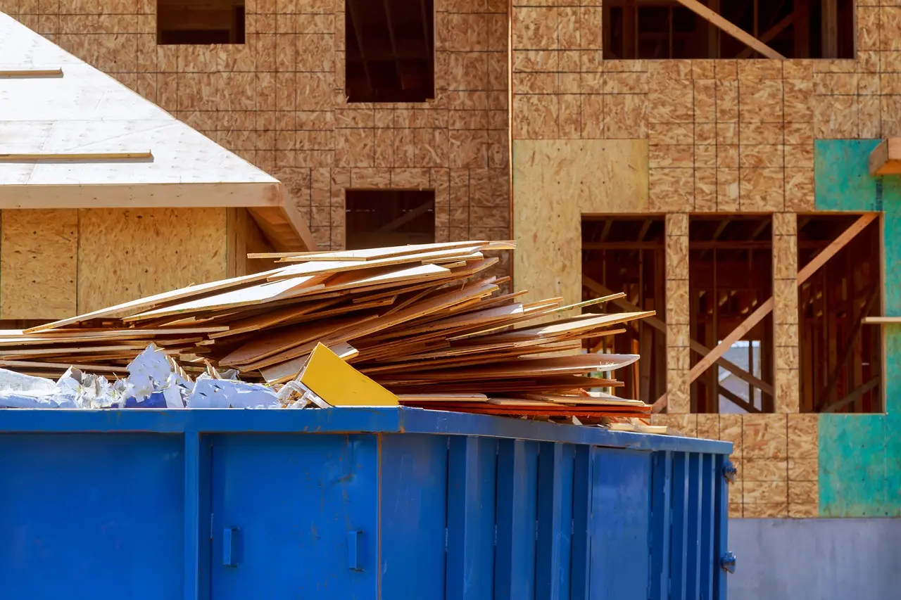 Plywood scraps piled in container for home renovation dumpster rental