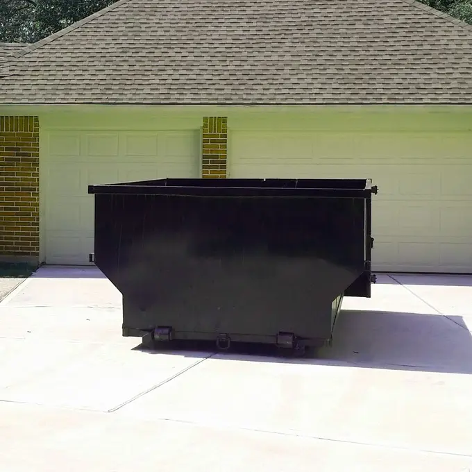 15-yard dumpster roll-off container parked on residential concrete driveway