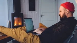 hipster-guy-with-laptop-in-cozy-room