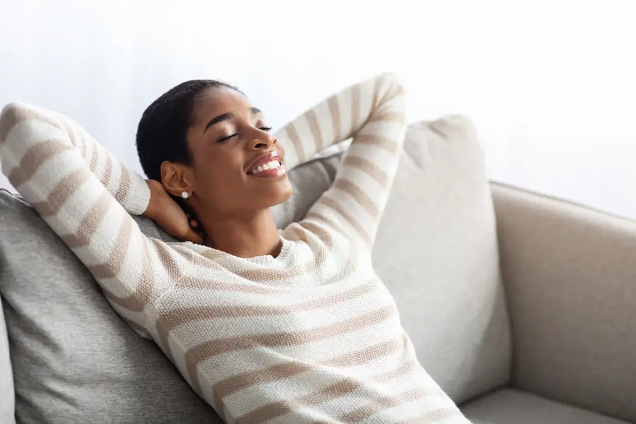relaxed women enjoys comfy home using smart home thermostats