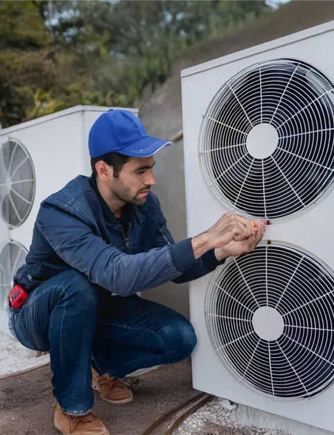 HVAC technician working on heat pump outdoors