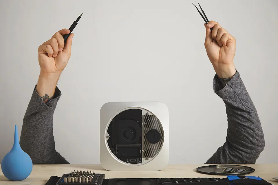 A person holding tweezers over an outlet, ready to fix.