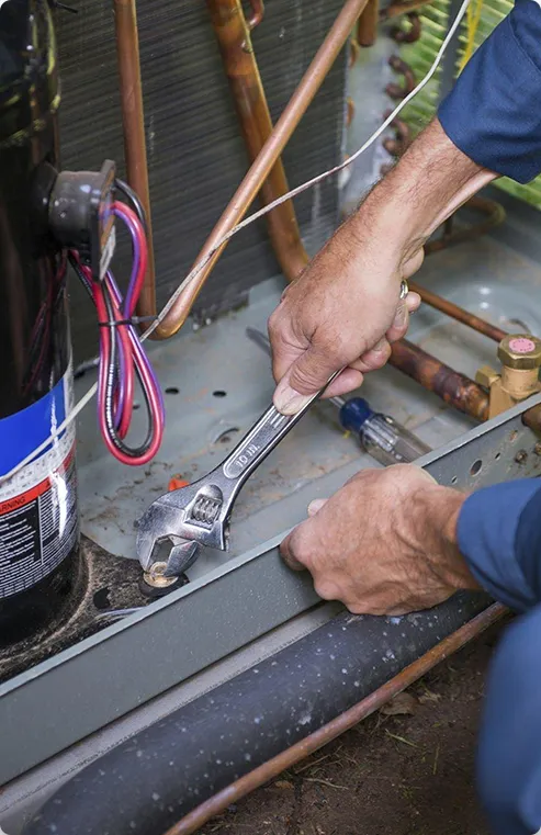 Man performing an ac service on an outdoors unit