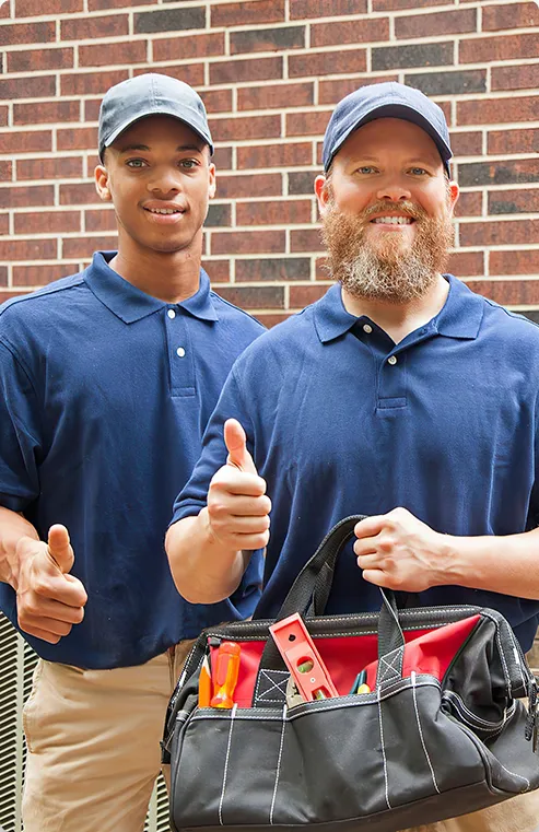 Two technicians from Shipton's in blue shirts and hats.