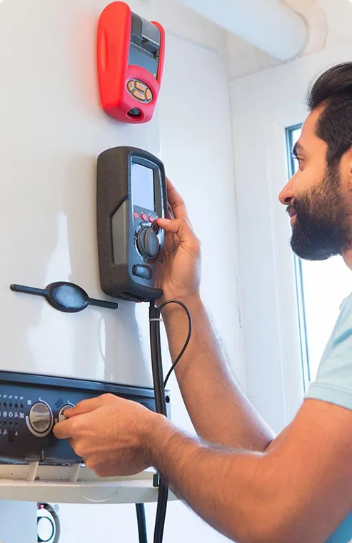 Man adjusting boiler thermostat