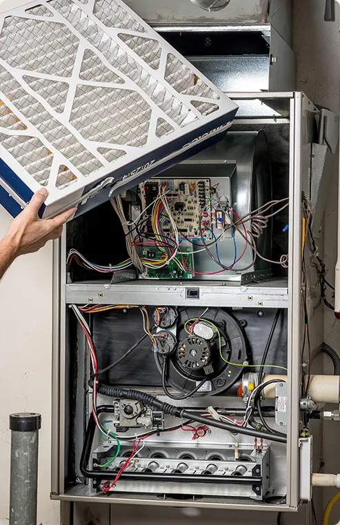 Person replacing a filter on a furnace