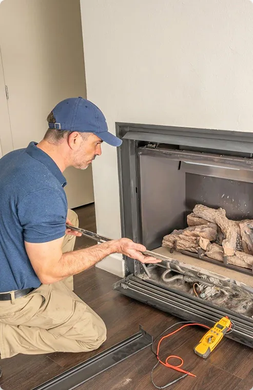 Man inspecting gas fireplace