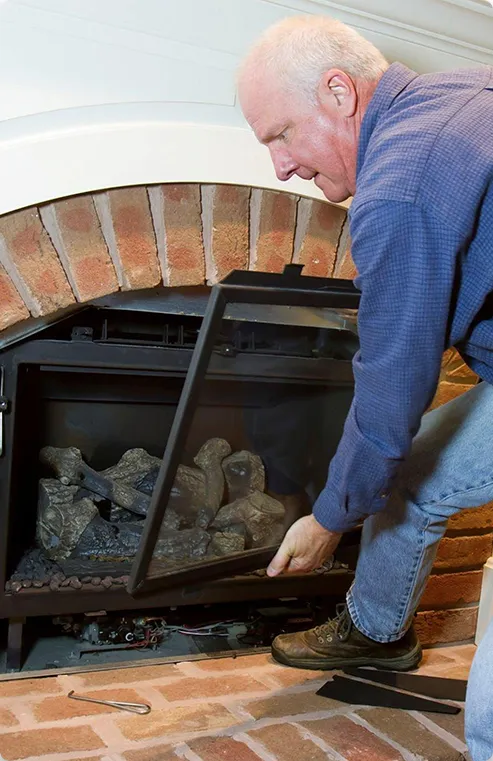 Older man checking his gas fireplace