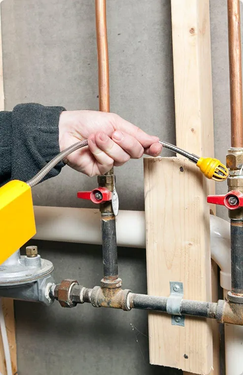 Man using a leak detector on gas pipes