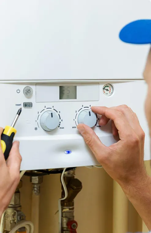 Man handling tankless water heater thermostat