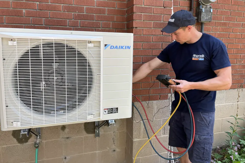 Heat Pump Maintenance Frequency in Hamilton ON - Shipton's technician doing maintenance on a heat pump.