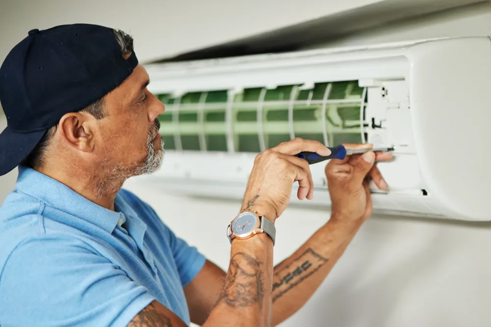 HVAC technician doing maintenance on a mini-split ac unit.