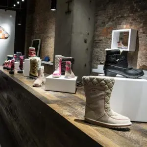 Boots displayed on white lacquer rectangle waterfall display sets in a retail store