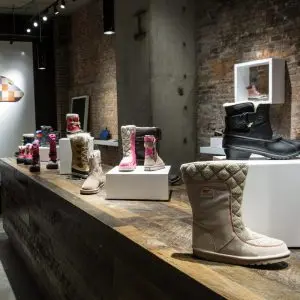 Boots displayed on white lacquer rectangle waterfall display sets in a retail store