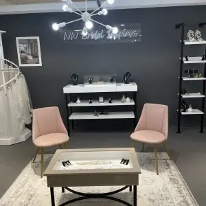 Boutique accessory display with pink chairs and shelving