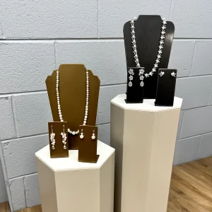 Jewelry display busts and stands on a white pedestal