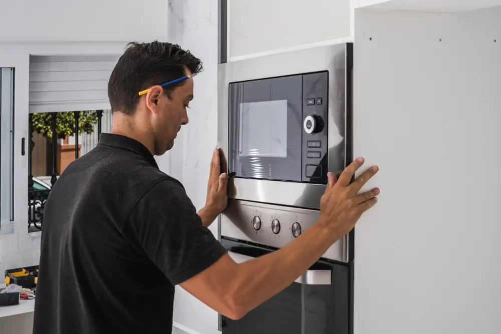 Appliance Installation Services in London, ON - Professional technician installing a wall mounted microwave