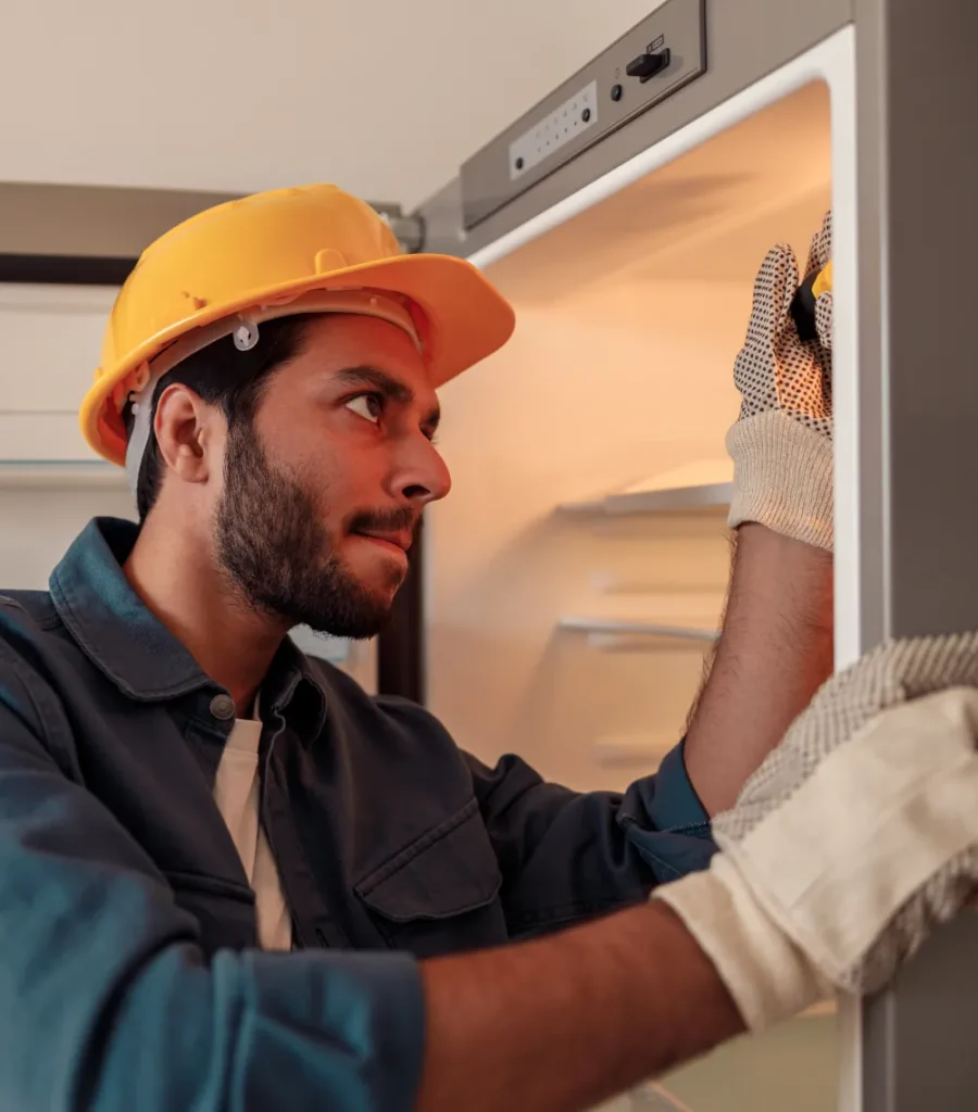 HVAC technician examining a fridge