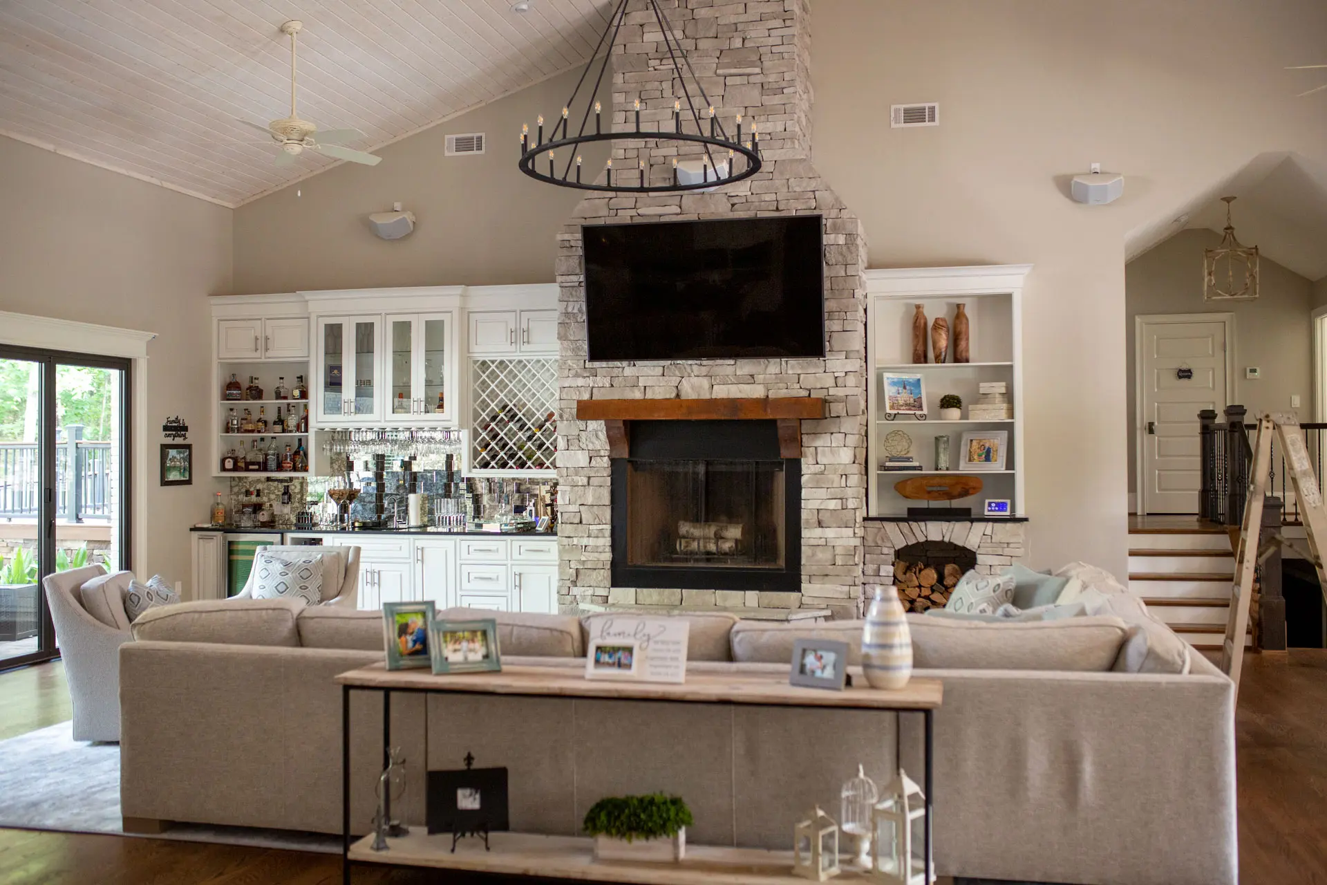 Living room with vaulted ceiling, ceiling fan and stone fireplace
