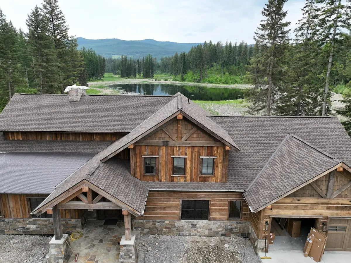 wood siding house with pond montana asphalt roof
