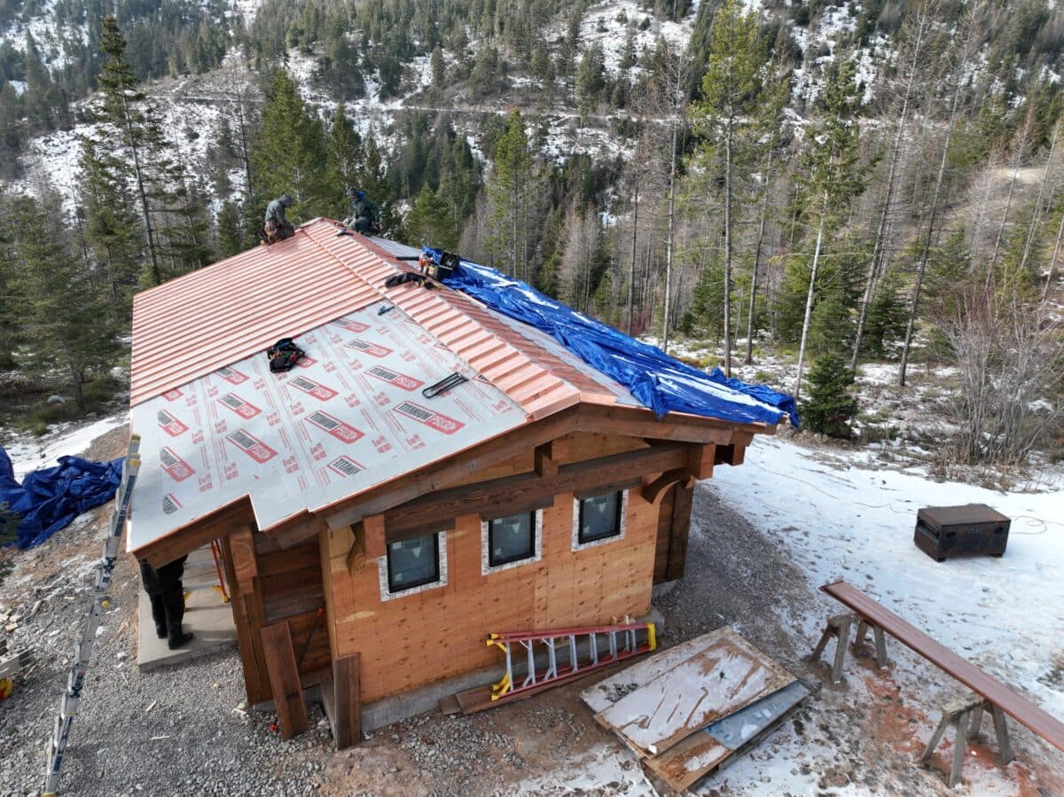 metal roof replacement workers removing tarp and replacing roof