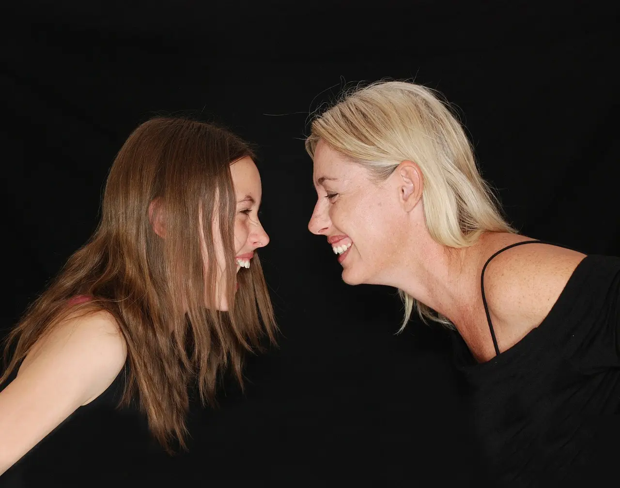 mom and teenage daughter laughing