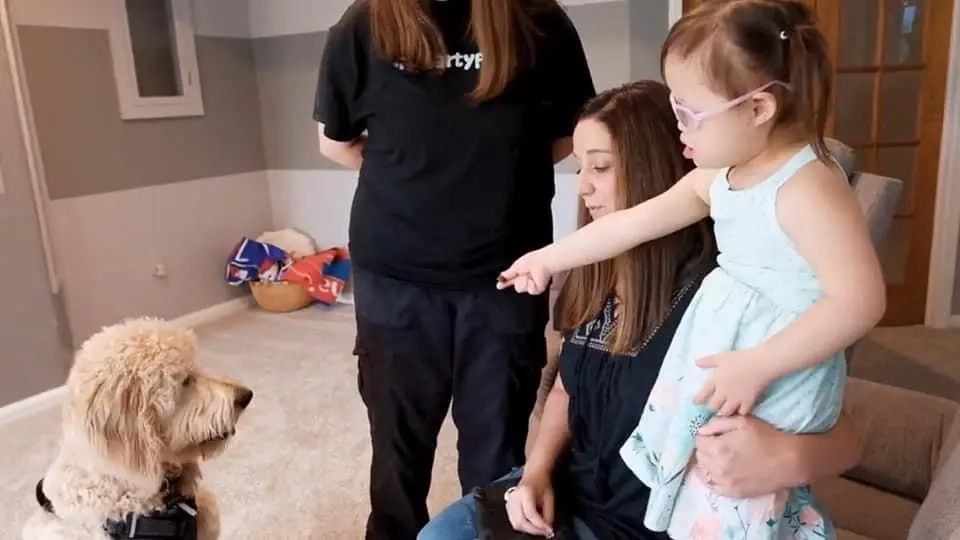 Picture of child and parent offering treat to dog.
