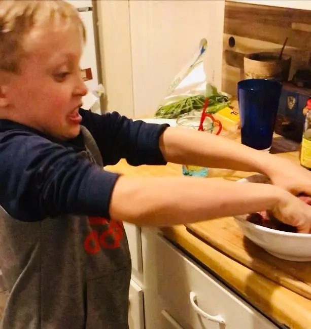 boy making meatballs in the kitchen 