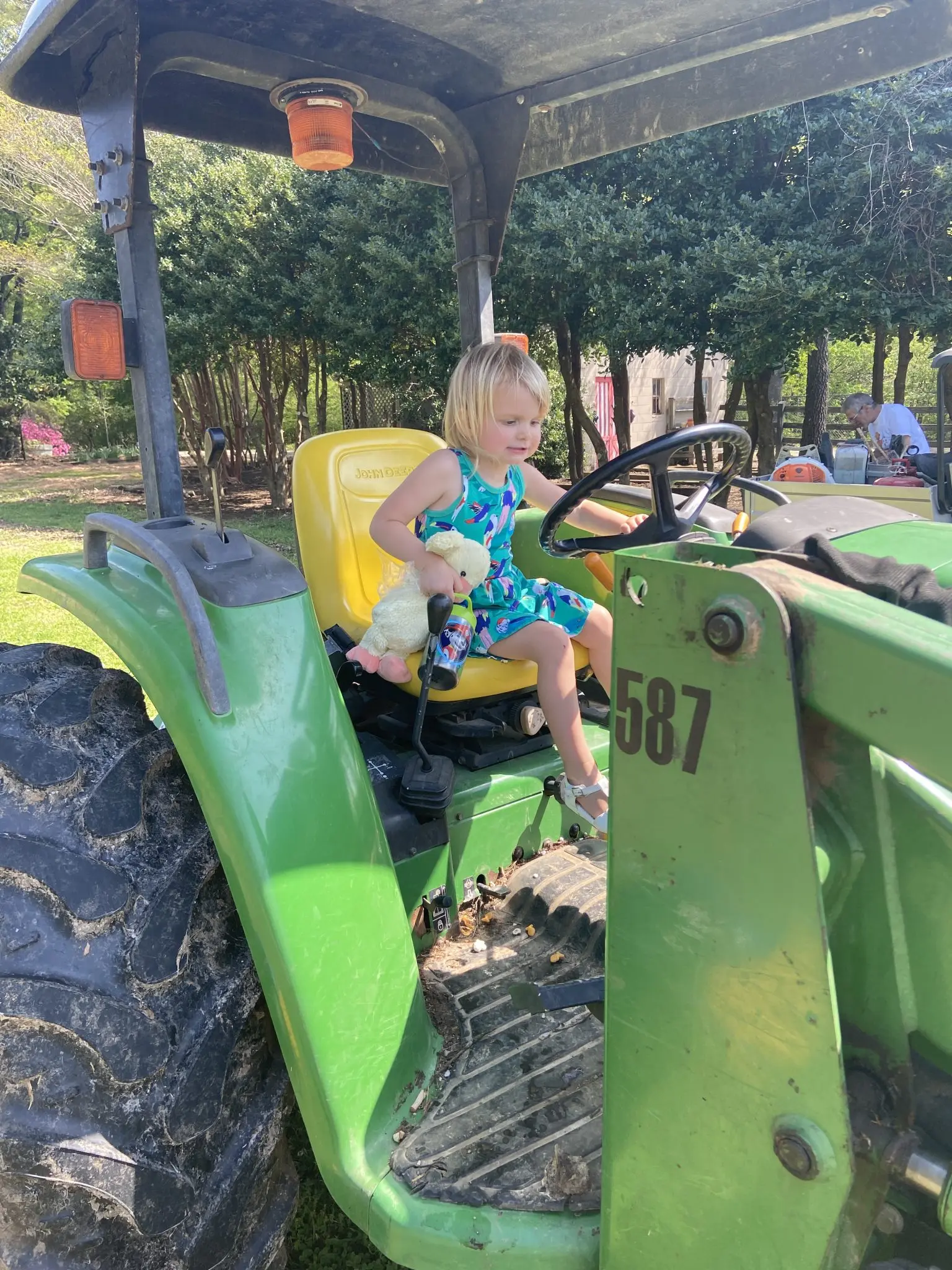 Girl on a green tractor in Bobby Lanier Farm Park