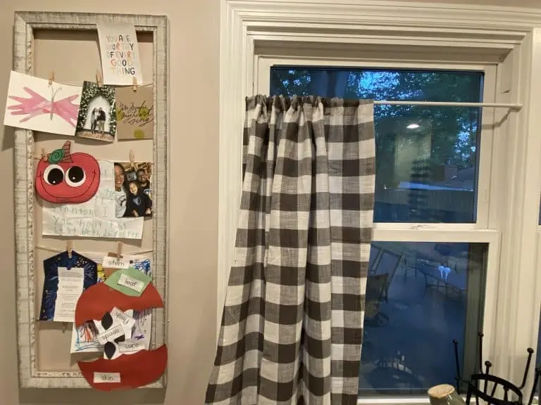 Picture frame with pictures and artwork clipped to yarn