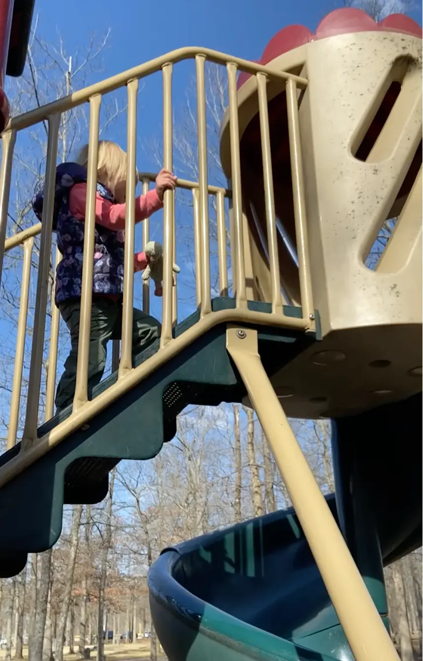 Kid climbing up the stairs to a slide