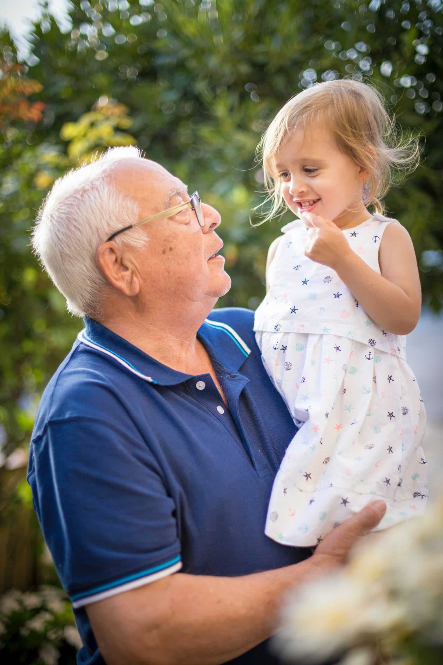 grandparent holding his granddaughter 