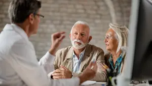 Doctor speaking with Retired couple discussing Medicare options