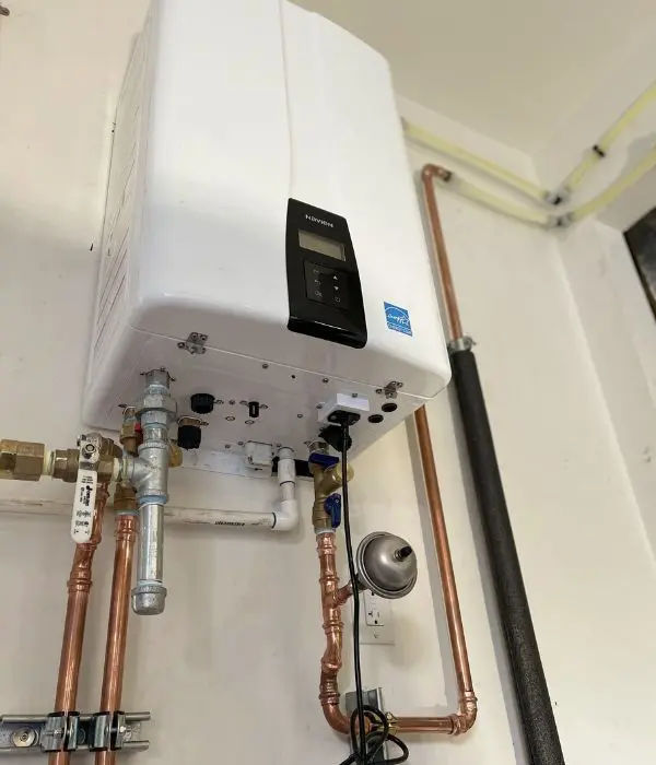 Technician repairing a wall-mounted tankless water heater | Tankless Water Heater Repair and Installation