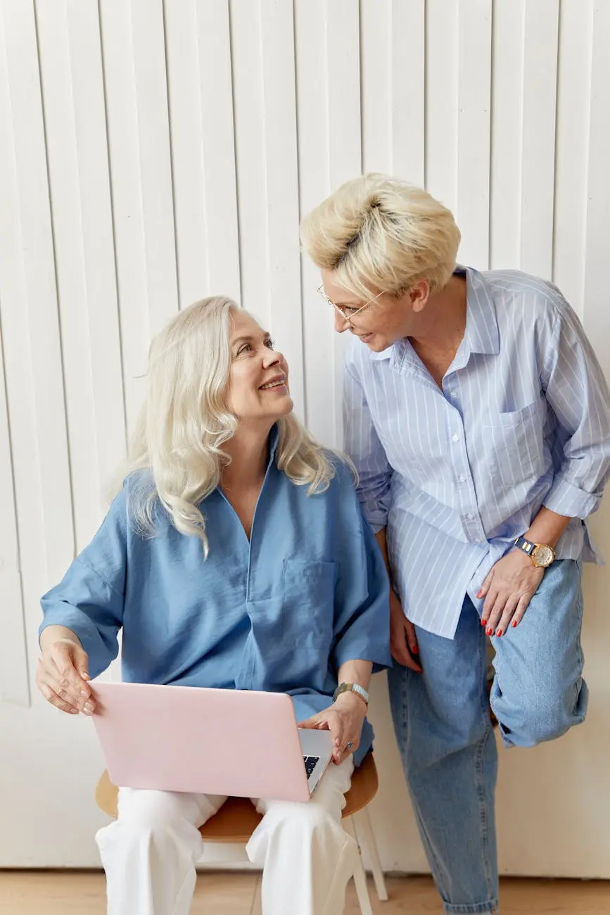 women in blue shirts holding a laptop computer