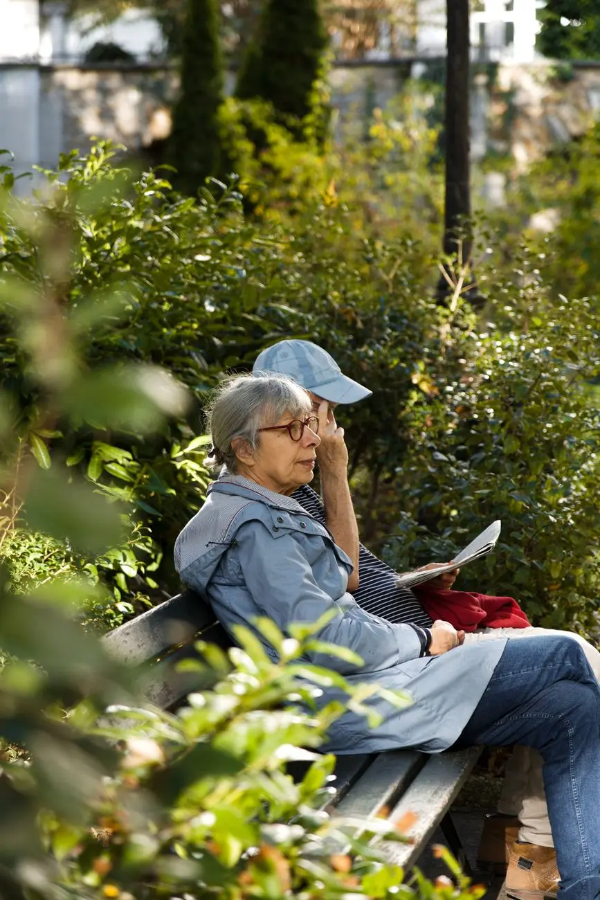 elderly woman and a man sitting on bench