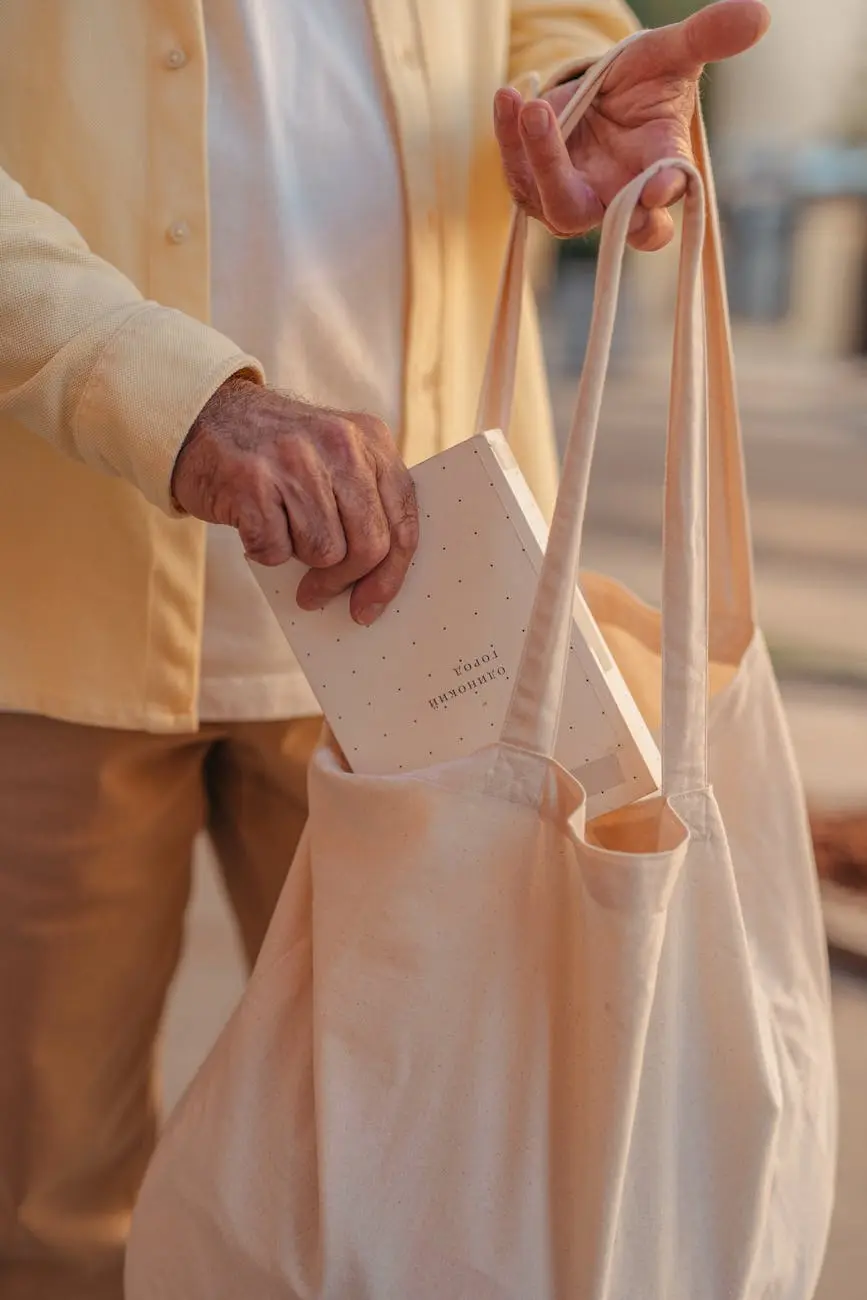 person putting a book in canvas tote bag