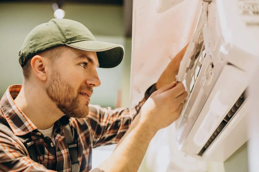 An AC technician making sure an AC unit is correctly installed.