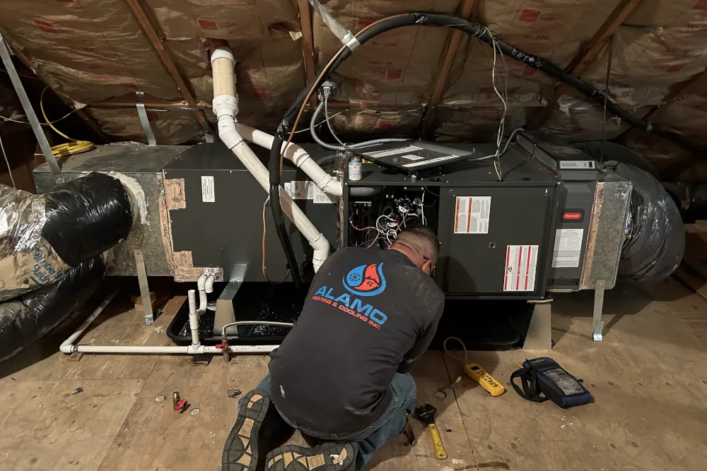 Alamo Heating & Cooling Inc. technician working on a newly installed furnace.