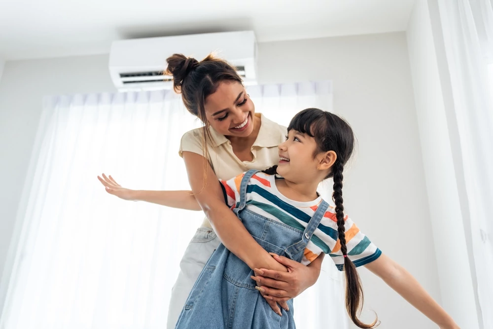 A woman hugging her child next to a recently purchased ac unit