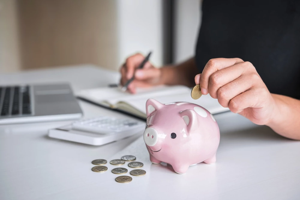 Woman putting money in a piggy bank
